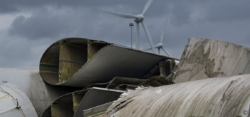 Windrad mit ausgedienten Rotorblätter im Vordergrund