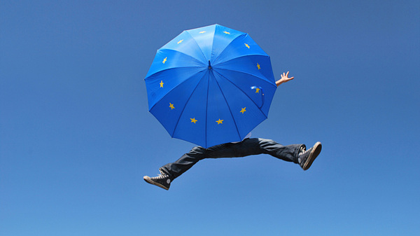 Person jumps with an EU umbrella