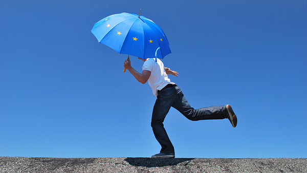 Man balancing with a Europe umbrella