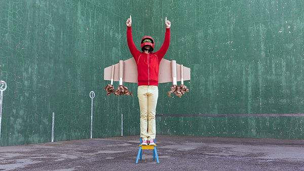  Child with rocket wings and in helmet celebrates victory