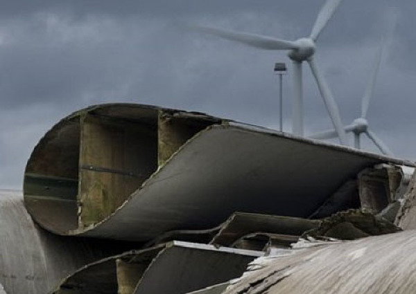 Bild einer Windenergieanlage im Vordergrund sieht man ausgediente Rotorblötter