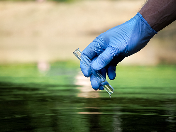 Hand hält Wasserprobe